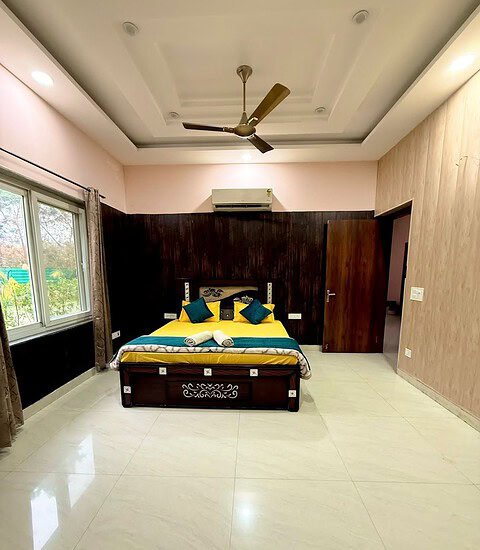 Spacious farmhouse bedroom featuring contemporary design, large windows, and comfortable bedding for.