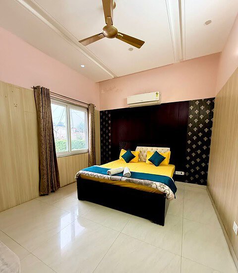 Comfortable farmhouse bedroom featuring a large bed, stylish decor, and ample natural sunlight. Perf.