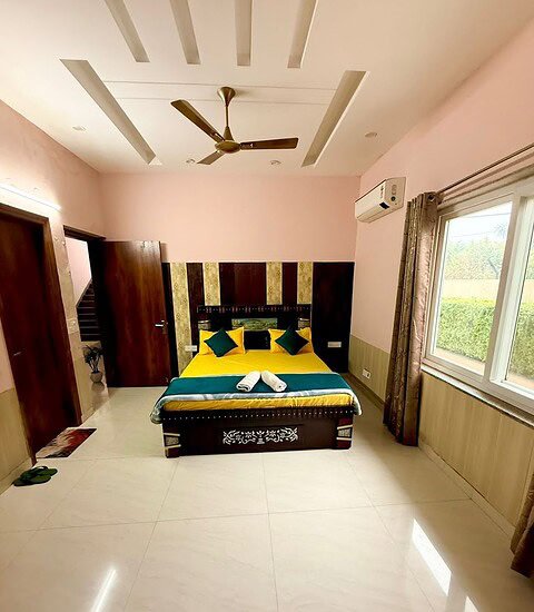 Spacious bedroom in Farmhouse 306 with modern decor and comfortable bedding at Golden Venue.