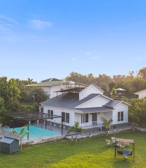 Aerial view of Golden Venue Luxhaven farmhouse in Noida with private pool, pergola and a large green lawn
